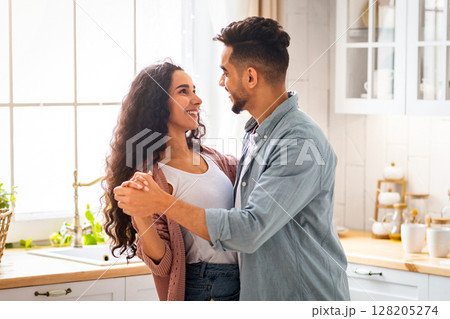 Loving Arab Spouses Dancing In Kitchen Interior, Romantic Middle Eastern Couple Looking At Each Other And Smiling, Modern Muslim Couple Having Fun At Home, Enjoying Spending Time Together, Copy Space Loving Arab Spouses Dancing In Kitchen Interior, Romantic Middle Eastern Couple Looking At Each Other And Smiling, Modern Muslim Couple Having Fun At Home, Enjoying Spending Time Together, Copy Space 128205274