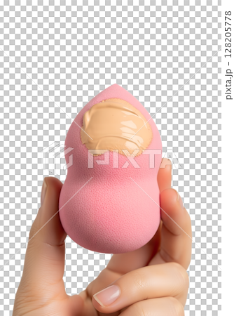 Pink makeup sponge with liquid foundation in hand, beauty blender isolated on transparent background, cosmetic application, flawless skin, blending tool 128205778