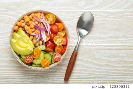 Vibrant vegetarian chickpea salad with fresh vegetables in ceramic bowl top view Vibrant vegetarian chickpea salad with fresh vegetables in ceramic bowl top view 128206311