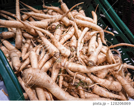 Freshly harvested roots piled together in a basket showcasing their unique shapes and textures, representing a natural and organic food concept Freshly harvested roots piled together in a basket showcasing their unique shapes and textures, representing a natural and organic food concept 128206869