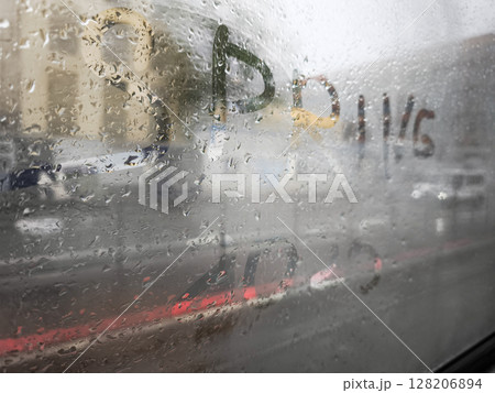 Rainy window with colorful writing creating a blurred view of the outside world, evoking a sense of nostalgia and reflection, spring season concept Rainy window with colorful writing creating a blurred view of the outside world, evoking a sense of nostalgia and reflection, spring season concept 128206894