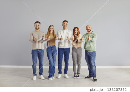 Group portrait of happy people showing thumb up gesture of satisfaction or approval  128207852