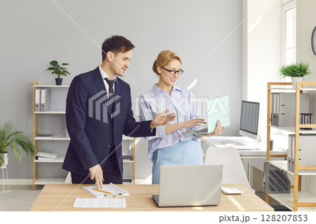 Two accountants looking at a business document on the screen of a laptop computer Two accountants looking at a business document on the screen of a laptop computer 128207853