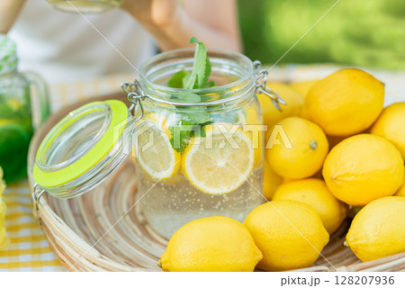 Plate with ripe fresh lemons and lemonade sassy water. Vitamins concept. copy space. Strengthening immunity concept. Tropical fruit. Organic citrus fruits for a healthy diet. Plate with ripe fresh lemons and lemonade sassy water. Vitamins concept. copy space. Strengthening immunity concept. Tropical fruit. Organic citrus fruits for a healthy diet. 128207936