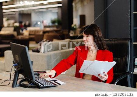Businesswoman working with computer and documents in modern office 128208132