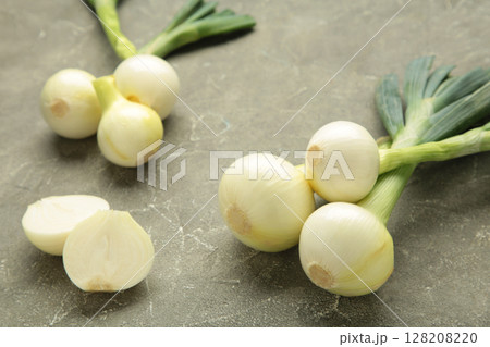 Green onion on grey concrete background. 128208220