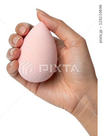 Hand holding soft pink makeup sponge isolated on transparent background, beauty blender, cosmetic tool, flawless foundation application 128210696