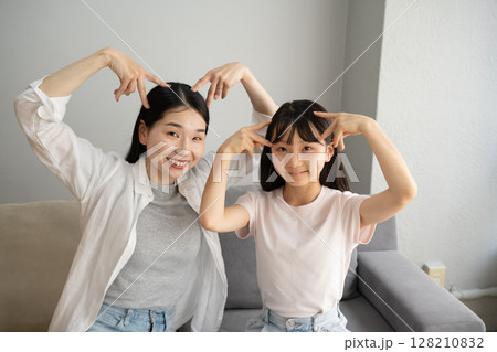 屋内で猫みみをする母娘 屋内で猫みみをする母娘 128210832