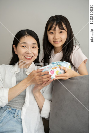 母にプレゼントを渡す娘 母にプレゼントを渡す娘 128210839