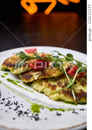 Zucchini fritters with fresh tomato and herbs Zucchini fritters with fresh tomato and herbs 128211237