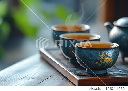 Set of cups with tea and teapot on wooden stand with blurred background and copy space. Tea ceremony. Generated by artificial intelligence 128211683