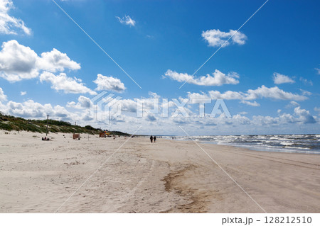Curonian spit on a sunny summer day. Scenic view of the beach on the Baltic Sea coast in the village of Nida, Lithuania. Gray sand dunes. Curonian spit on a sunny summer day. Scenic view of the beach on the Baltic Sea coast in the village of Nida, Lithuania. Gray sand dunes. 128212510