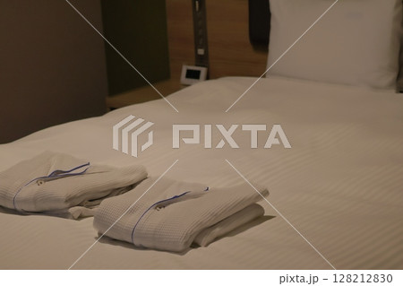 寝間着の置いてあるベッドのあるホテルの部屋の風景 寝間着の置いてあるベッドのあるホテルの部屋の風景 128212830