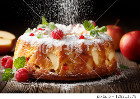 Delicious Bundt Cake with Icing Sugar and Fresh Fruits on Rustic Wooden Table 128213579