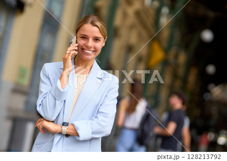 A Professional Woman Engaged in a Phone Call While in an Urban Setting Full of Life 128213792