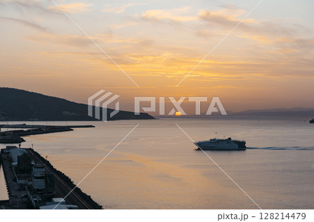 View of a ferry at sunset entering the port of Ceuta View of a ferry at sunset entering the port of Ceuta 128214479