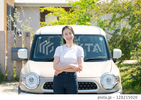 車の横に立つ若い女性 128215020
