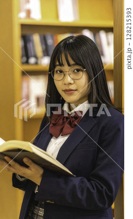 眼鏡をかけた女子高校生が図書館で読書｜知性と落ち着きを感じる学びの瞬間 128215393