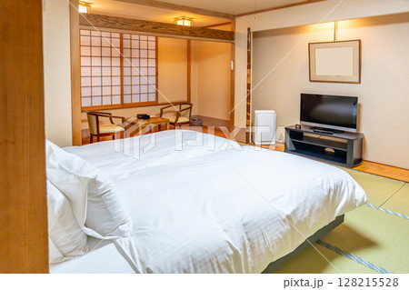 畳の和室にベッドの置かれた和風旅館の客室 128215528