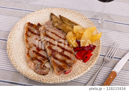 Delicious mediterranean style steak served with baked tomatoes calcot onion and tomatoes Delicious mediterranean style steak served with baked tomatoes calcot onion and tomatoes 128215816