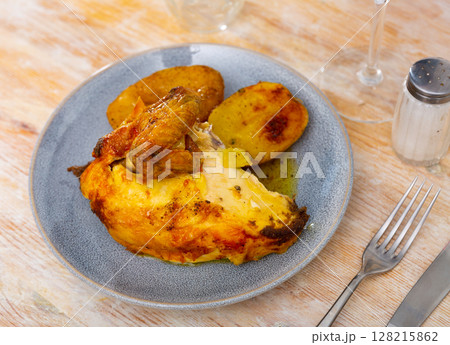 Tasty roasted chicken thigh served with boiled potatoes Tasty roasted chicken thigh served with boiled potatoes 128215862