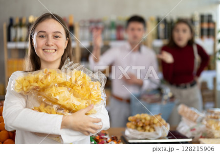 Daughter chose pile of potato chips in store, and quarrels with parents over choice of food Daughter chose pile of potato chips in store, and quarrels with parents over choice of food 128215906