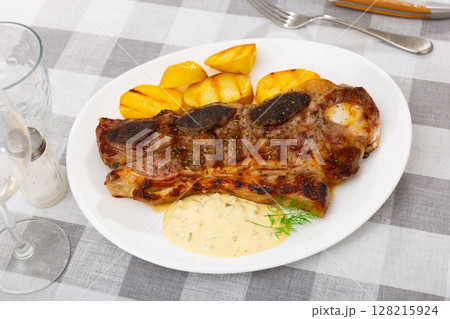 Grilled beef spare ribs with baked potatoes and sauce 128215924