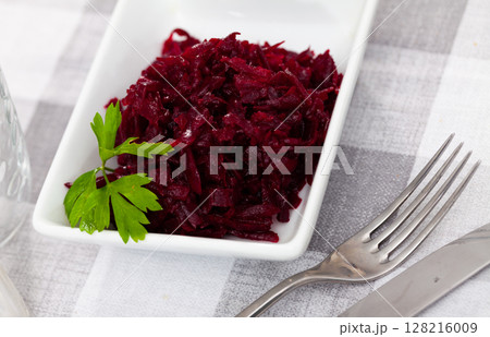 Portion of salad made of boiled and grated beetroot 128216009