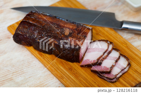 Sliced smoked pork bacon on wooden cutting board Sliced smoked pork bacon on wooden cutting board 128216118