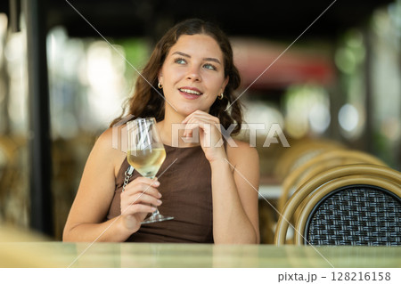 Beautiful woman relaxing and drinking white wine while sitting on terrace of street cafe of Barcelona Beautiful woman relaxing and drinking white wine while sitting on terrace of street cafe of Barcelona 128216158