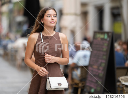 Young woman walking around summer european city 128216206