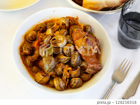 Stewed snails with rabbit meat and sausages 128216318
