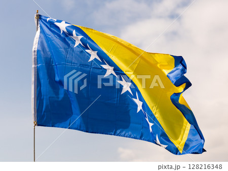 Flag of Bosnia and Herzegovina waving on cloudy sky during daytime Flag of Bosnia and Herzegovina waving on cloudy sky during daytime 128216348