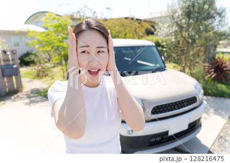車の横で頭を抱える女性 車の横で頭を抱える女性 128216475
