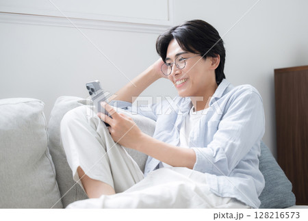 スマホを見る、持つ眼鏡のハンサムな男性 スマホを見る、持つ眼鏡のハンサムな男性 128216573