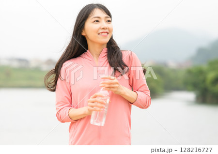 公園で水分補給をする女性 128216727