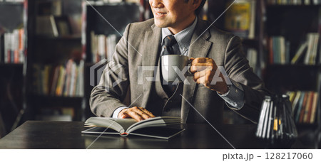 図書館,書斎でコーヒーを飲むアジア人男性ビジネスマン（読書・文学・教養・レトロ・アンティーク） 128217060