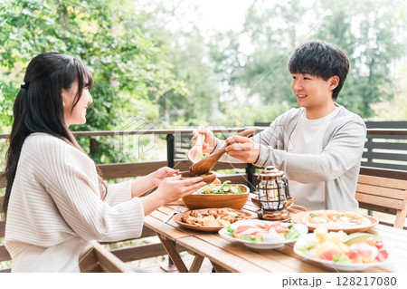 ウッドデッキ・テラス席・バルコニー席で食事するカップル・夫婦(グランピング・ベランピング) ウッドデッキ・テラス席・バルコニー席で食事するカップル・夫婦(グランピング・ベランピング) 128217080