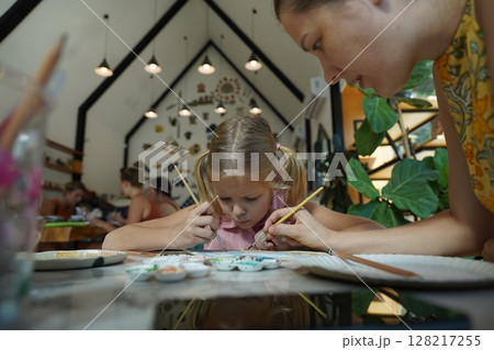 A young mother and her daughter enjoy a creative art session at home A young mother and her daughter enjoy a creative art session at home 128217255