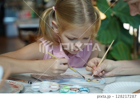 A young mother and her daughter enjoy a creative art session at home  128217287