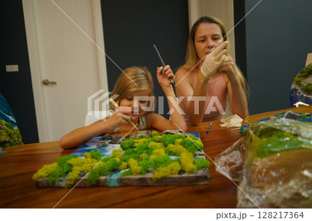 A mother and her daughter craft vibrant natural landscapes A mother and her daughter craft vibrant natural landscapes 128217364