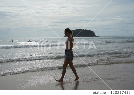 A young woman enjoying a beautiful day at the beach  128217435
