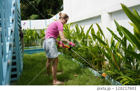 A young woman trims her beautiful garden  128217601