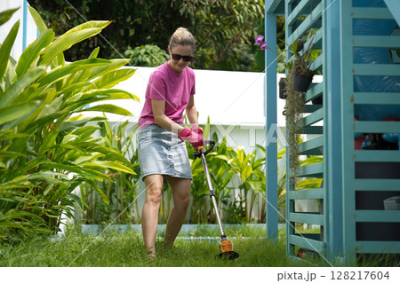 A young woman trims her beautiful garden A young woman trims her beautiful garden 128217604