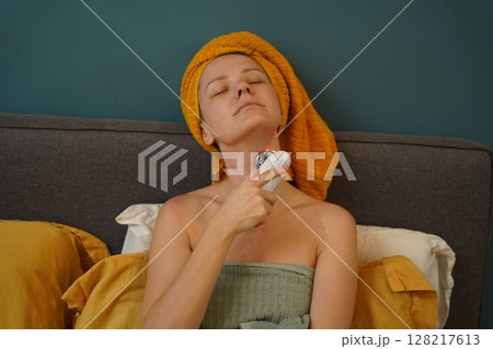 Young woman using infrared massager  128217613