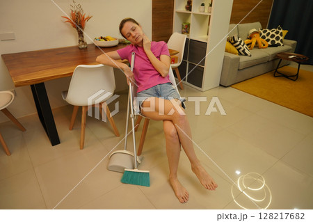 A woman is cleaning her living room at home 128217682