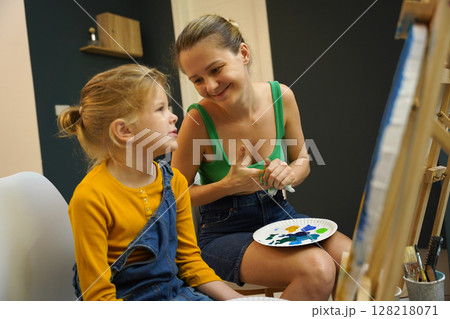 Teacher in workshop teched two girls how to assemble a thermo mosaic  128218071