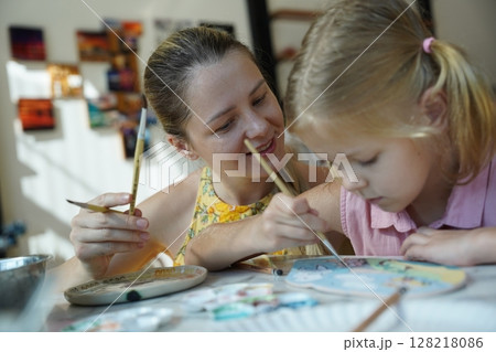 A young mother and her daughter enjoy a creative art session at home  128218086
