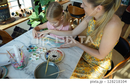 A young mother and her daughter enjoy a creative art session at home  128218104