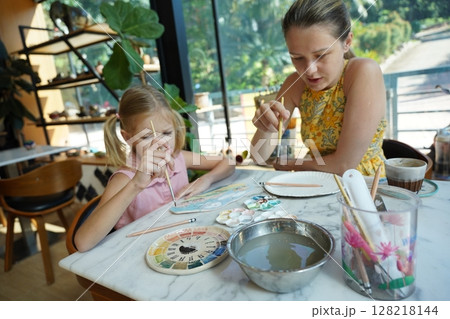 A young mother and her daughter enjoy a creative art session at home A young mother and her daughter enjoy a creative art session at home 128218144